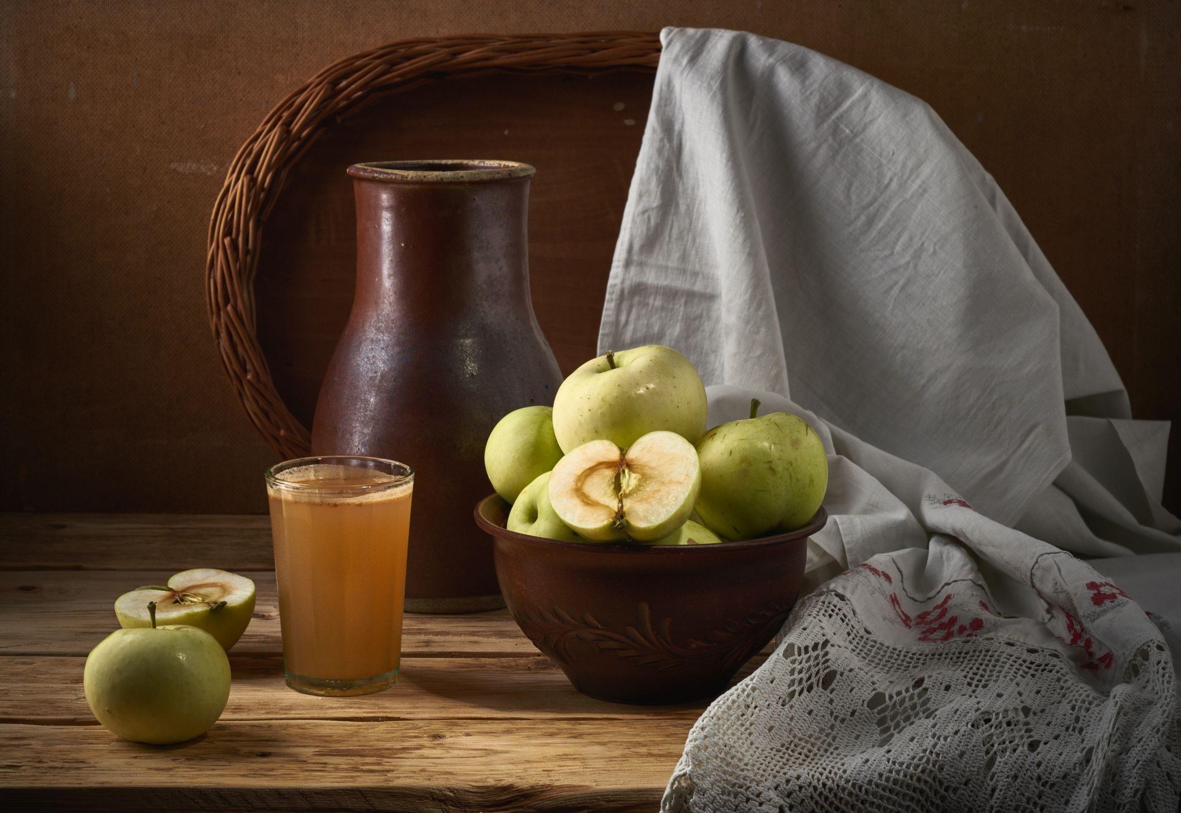 Pommes, pichet et verre de cidre sur une table