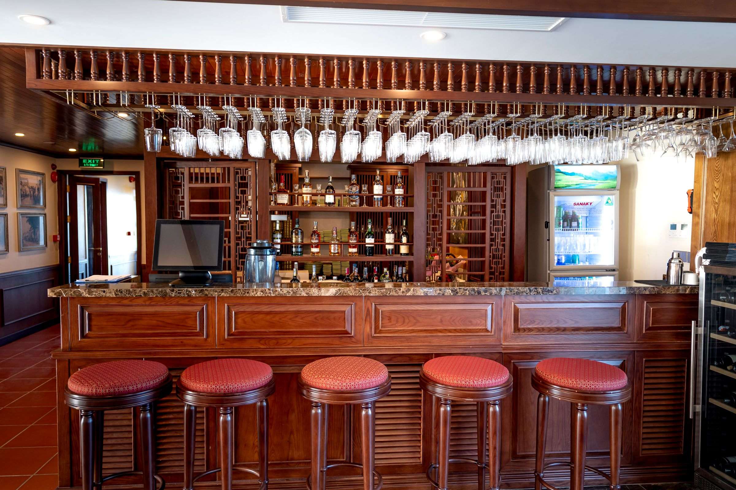 Comptoir en bois d’un bar avec ses tabourets