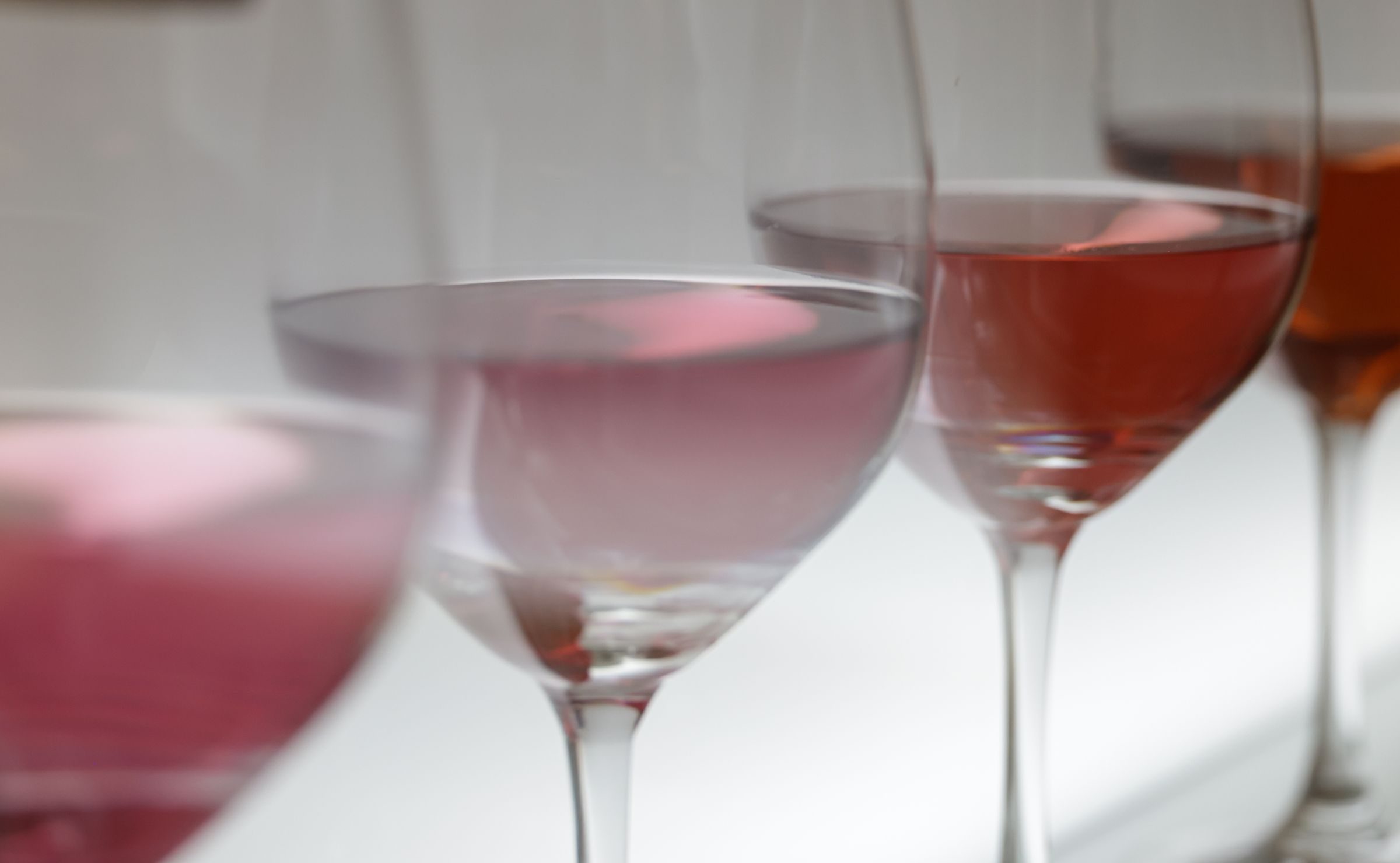 Verres à pied remplis de vin rosé, vus de près