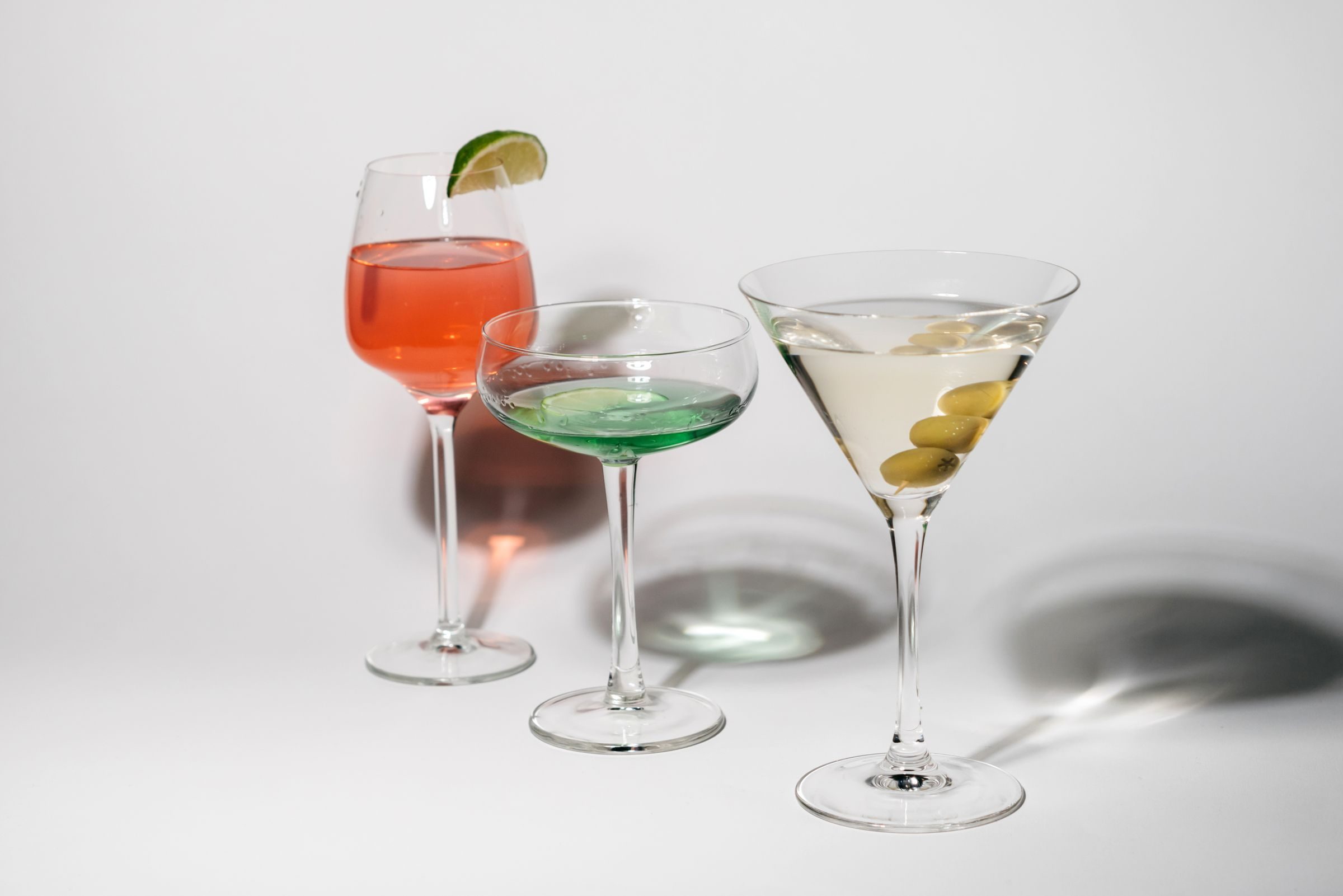 Trois verres à cocktail sur fond blanc